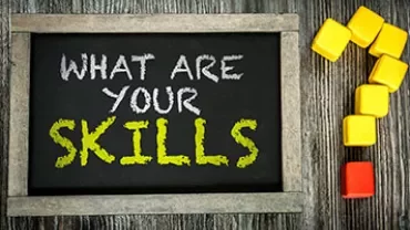 Svart tavla med texten 'What are your skills?' och färgglada block i form av ett frågetecken.