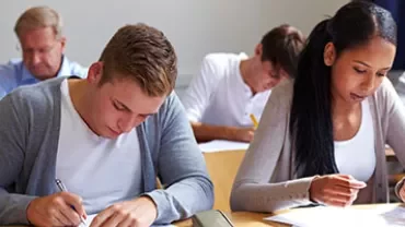 Studenter som fokuserar på ett prov i ett klassrum.