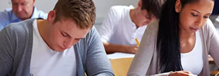 Studenter som fokuserar på ett prov i ett klassrum.