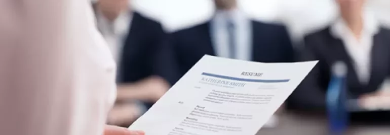 Person håller ett CV under en arbetsintervju.