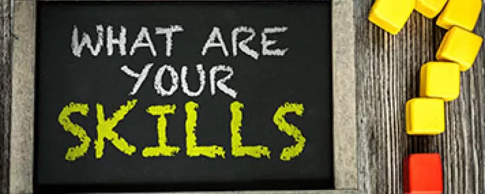 Svart tavla med texten 'What are your skills?' och färgglada block i form av ett frågetecken.